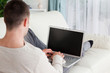 © WavebreakmediaMicro - Man lying on his couch to use a laptop