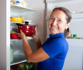 Poster - woman putting pan into refrigerator