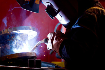 Wall Mural - factory worker welding metal and sparks spreading