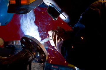 Wall Mural - factory worker welding metal and sparks spreading