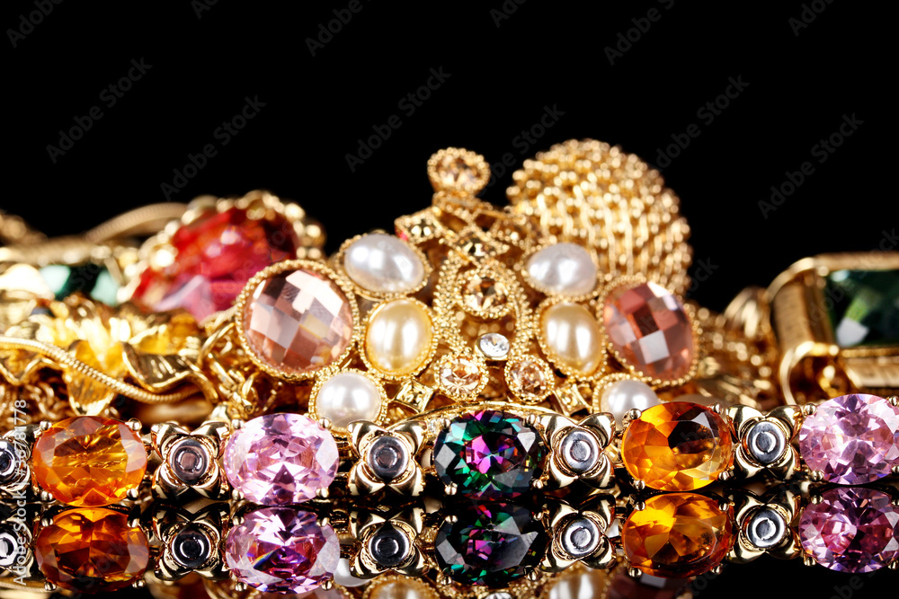 Various gold jewellery on black background