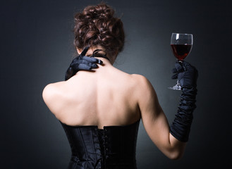 young ladies in elegant evening dress with a glass of red wine.