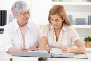 Mother and adult daughter doing paperwork