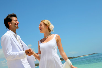 Wall Mural - Bride and groom dancing by blue lagoon