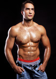 young muscular man isolated on black background
