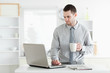 © WavebreakmediaMicro - Businessman using a laptop while drinking coffee