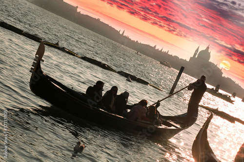 Fototapeta na wymiar Venice, Gondola against colorful sunset in Italy