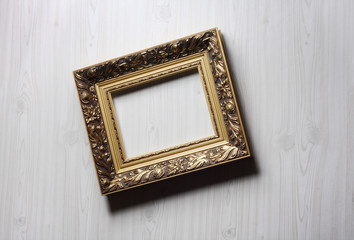 Wall Mural - Image of lopsided golden art frame on the wall in dramatic light