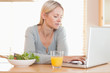 © WavebreakmediaMicro - Woman having healthy lunch while working on her laptop