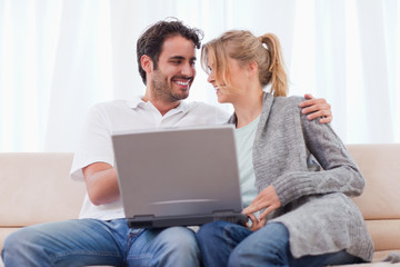 Poster - Young couple using a laptop