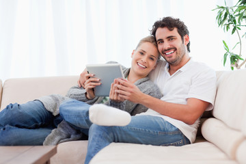 Poster - Happy young couple using a tablet computer