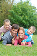 © goodluz - Portrait of happy family lying down in grass