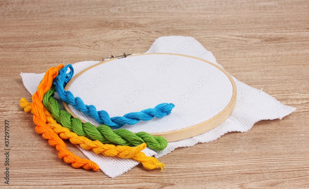 The embroidery hoop with canvas and bright sewing threads