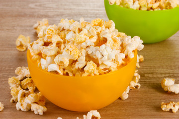 popcorn in bright plastic bowls on wooden table