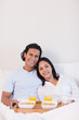 © WavebreakmediaMicro - Happy couple having breakfast in the bed