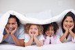 © WavebreakmediaMicro - Smiling family hiding under the blanket