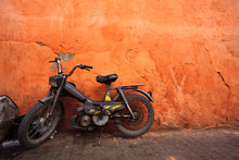 Old Moped Leans Against An Orange Wall