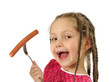 Little girl eating sausage