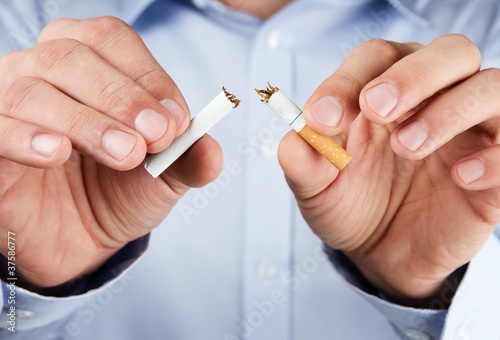 Fotomural Quit smoking, human hands breaking up cigarette