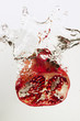 Pomegranate splashing into water
