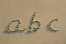 Alphabet Letters Handwritten In Sand On Beach
