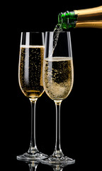 Champagne pouring into a glass on a black background