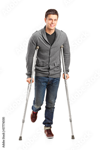 Fotomural Full length portrait of an injured young man on crutches