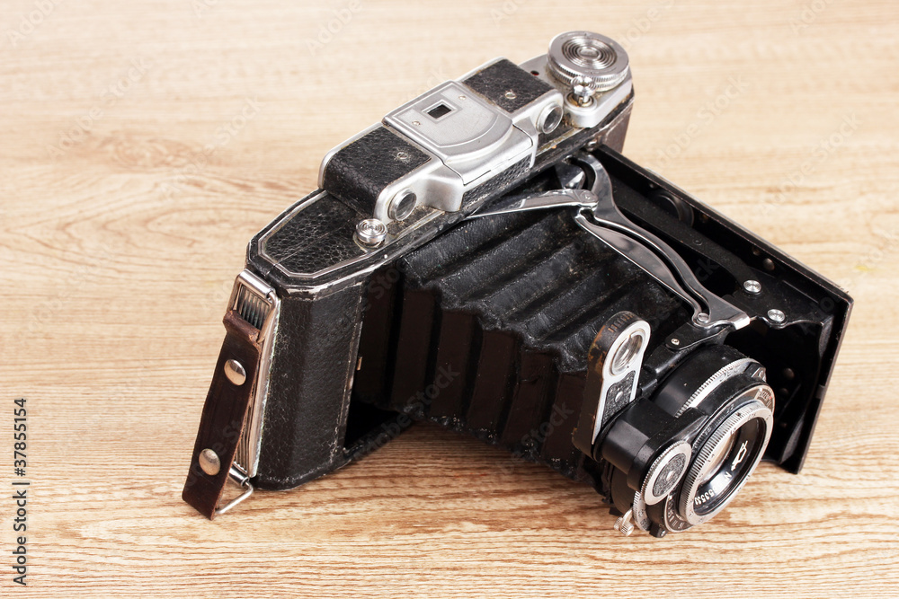 Old photo camera on wooden background