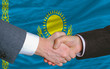 businessmen handshake after good deal in front of kazakhstan fla