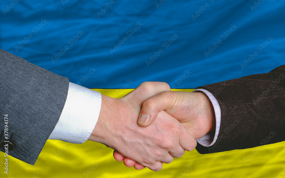 businessmen handshake after good deal in front of ukraine flag - obrazy, fototapety, plakaty 