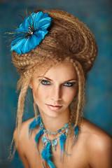 Beautiful girl with a blue flower in her hair