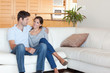 © WavebreakmediaMicro - Smiling couple sitting on a couch