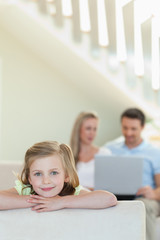 Poster - Smiling little girl with parents behind her
