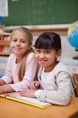 portrait of smiling schoolgirls reading a fairy tale