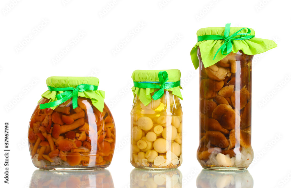 delicious marinated mushrooms in the glass jars isolated