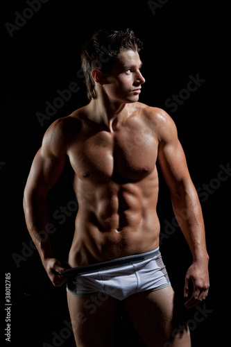Photographie The muscular young naked sexy boy takes off her underwear