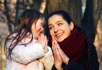 Mother teaching his little girl to pray.