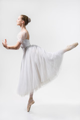 Beautiful ballerina dances in a white dress