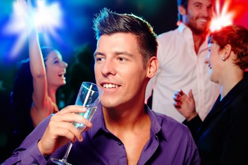 Poster - Young man drinking champagne at a party