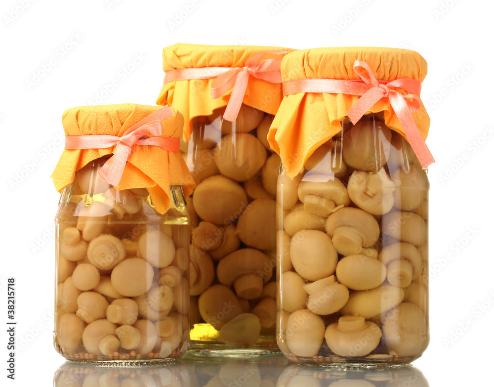delicious marinated mushrooms in the glass jars isolated