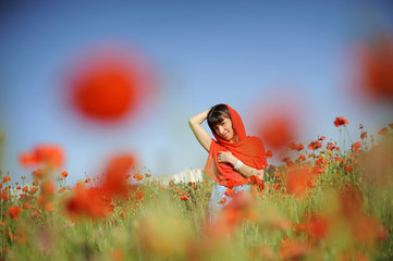 Sticker - Smiling girl in a red cloth among poppies