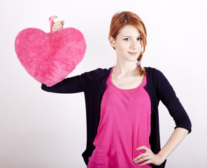 Beautiful red-haired girl with toy heart. Photo for st. Valentin