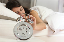 Woman Turning Off Alarm Clock