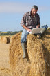 © auremar - Farmer with a laptop on a haystack