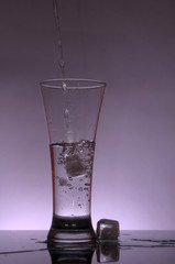 Poster - Water flows into the glass on violet
