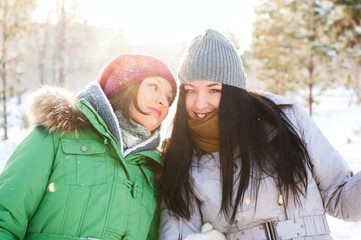 Two winter women walking and chatting together in winter park. B