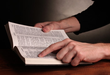 Reading open russian holy bible on wooden table