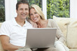 © spotmatikphoto - Happy Man & Woman Couple Using Laptop At home