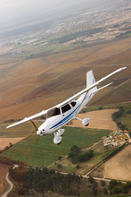Small Airplane Flying Over Farm