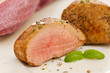 Slices of pork fillet on a plate seasoned with herbs